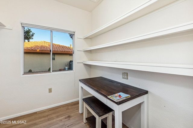 interior space with baseboards and wood finished floors