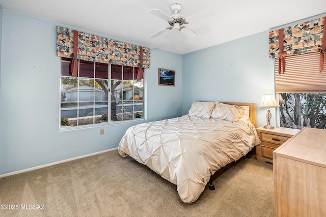 bedroom featuring baseboards, a ceiling fan, and light colored carpet