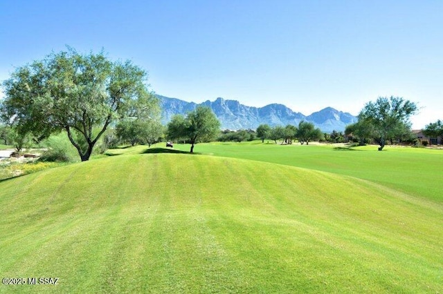 view of property's community featuring golf course view, a mountain view, and a lawn