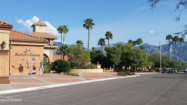 view of road with curbs, a mountain view, and sidewalks