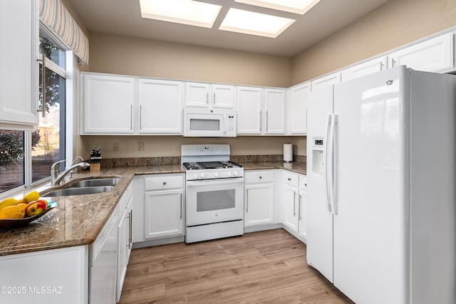 kitchen with a sink, light wood-type flooring, white cabinetry, and white appliances