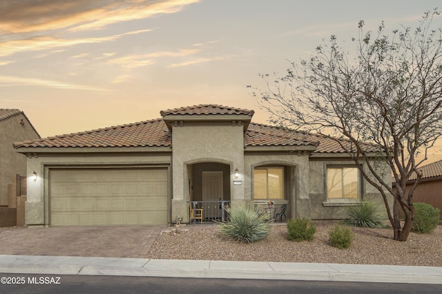 13906 N Rim Trl, Marana, AZ 85658 - mediterranean / spanish house featuring stucco siding, an attached garage, decorative driveway, and a tiled roof