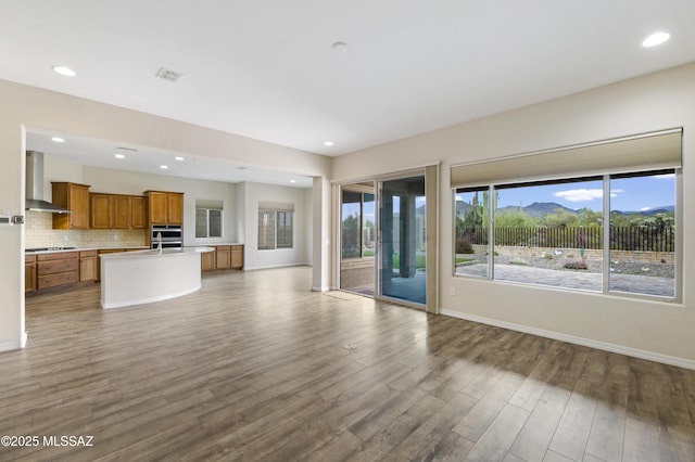 13906 N Rim Trl, Marana, AZ 85658 - unfurnished living room featuring wood finished floors, baseboards, and recessed lighting