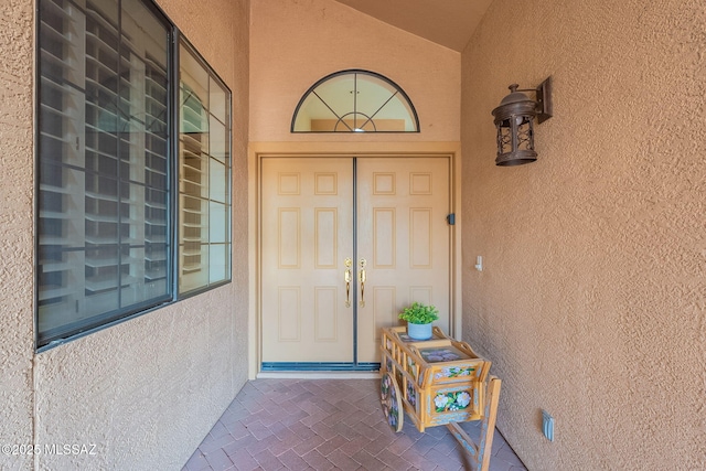 doorway to property featuring stucco siding