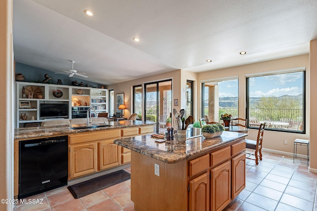 kitchen featuring a center island, black dishwasher, a sink, open floor plan, and stone countertops