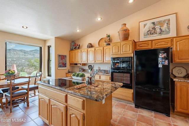 kitchen with a center island, black appliances, dark stone counters, and light tile patterned flooring