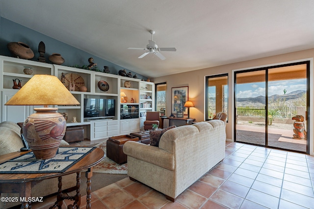 living room featuring light tile patterned floors, vaulted ceiling, and a ceiling fan