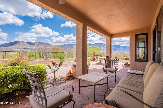 view of patio featuring outdoor dining area, a fenced backyard, a mountain view, and an outdoor hangout area