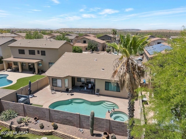 view of pool featuring an in ground hot tub, a residential view, a fenced in pool, a patio area, and a fenced backyard