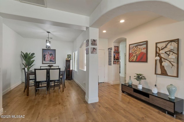 dining area with visible vents, baseboards, arched walkways, recessed lighting, and wood finished floors
