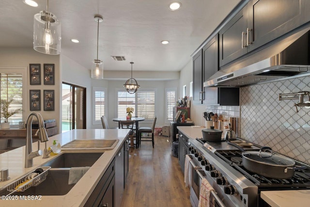kitchen featuring recessed lighting, under cabinet range hood, appliances with stainless steel finishes, a sink, and visible vents