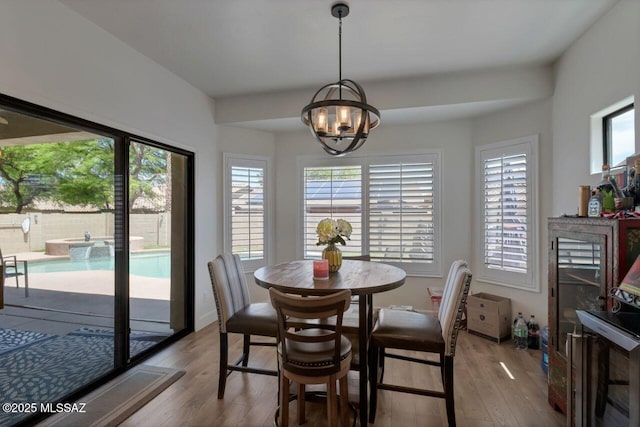 dining space with an inviting chandelier, hardwood / wood-style flooring, and a healthy amount of sunlight