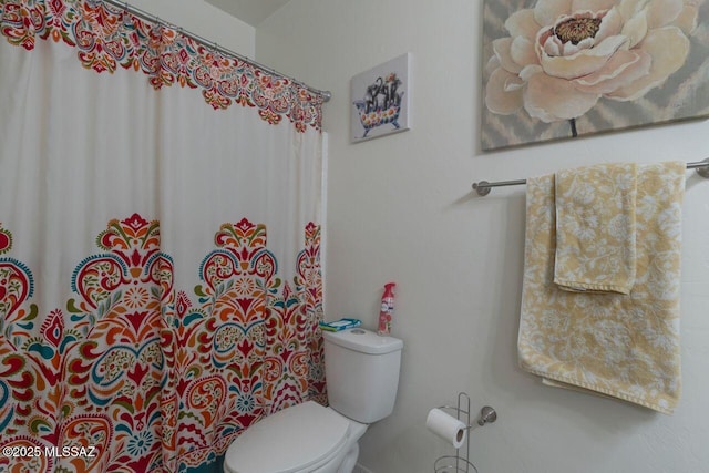 full bathroom with toilet and a shower with shower curtain