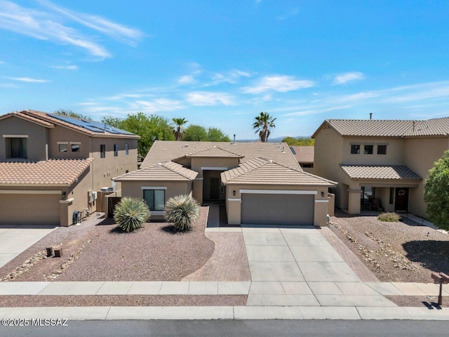 view of front facade featuring a tile roof, stucco siding, driveway, and an attached garage