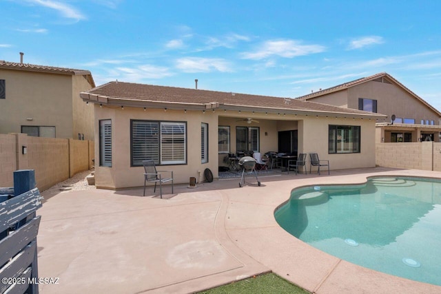 rear view of property with a fenced backyard, stucco siding, and a patio area