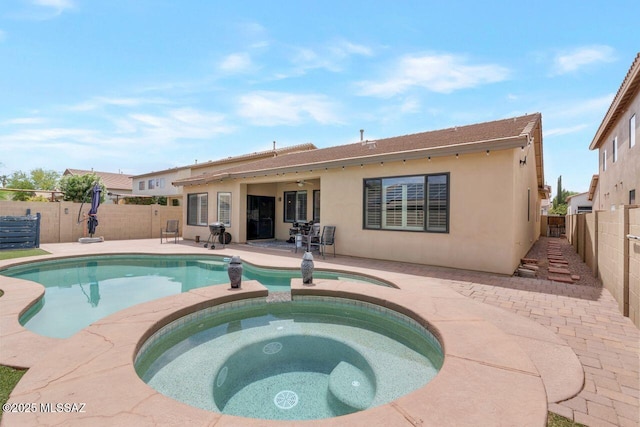 view of swimming pool with a pool with connected hot tub, a patio, a ceiling fan, and a fenced backyard