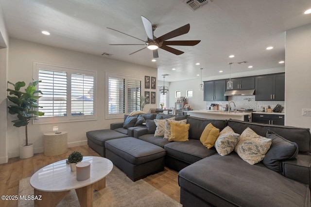 living room featuring visible vents, ceiling fan, light wood-style floors, and recessed lighting