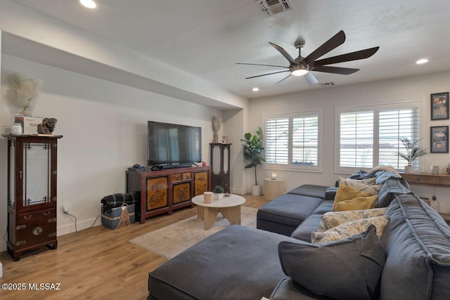 living area with visible vents, ceiling fan, baseboards, light wood-type flooring, and recessed lighting