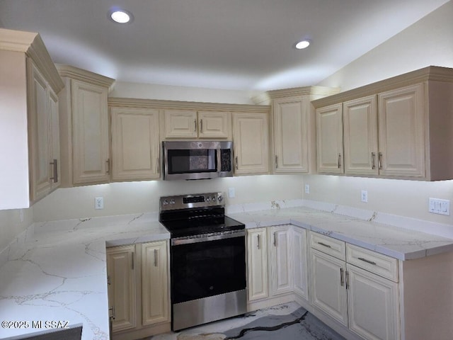 kitchen featuring appliances with stainless steel finishes, cream cabinets, light stone countertops, and recessed lighting