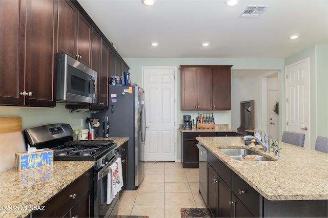 3295 W Sunlit Peak Dr, Tucson, AZ 85742 - kitchen with visible vents, light tile patterned floors, a sink, appliances with stainless steel finishes, and a center island with sink