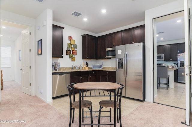 3295 W Sunlit Peak Dr, Tucson, AZ 85742 - kitchen with visible vents, dark brown cabinets, recessed lighting, stainless steel appliances, and light colored carpet