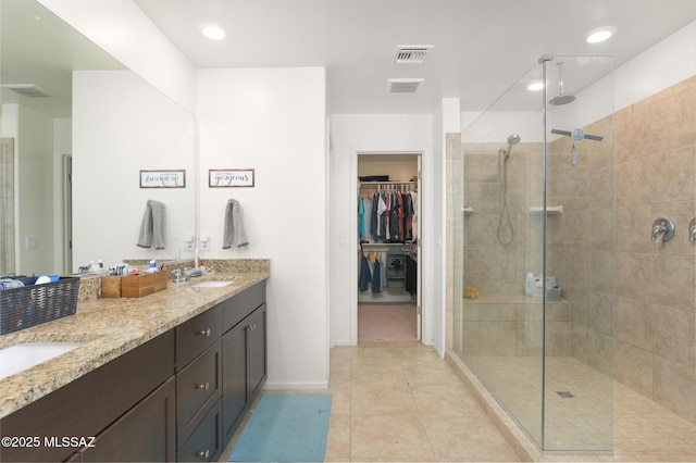 3295 W Sunlit Peak Dr, Tucson, AZ 85742 - full bathroom with visible vents, a sink, double vanity, tile patterned floors, and a stall shower