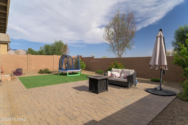 3295 W Sunlit Peak Dr, Tucson, AZ 85742 - view of patio with a trampoline, a fenced backyard, and an outdoor living space with a fire pit
