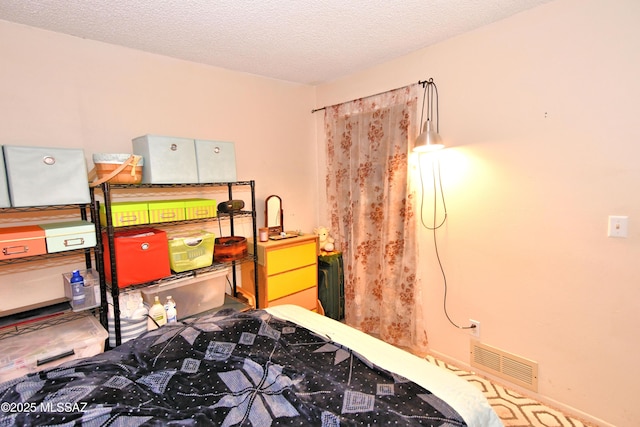 bedroom with a textured ceiling and visible vents
