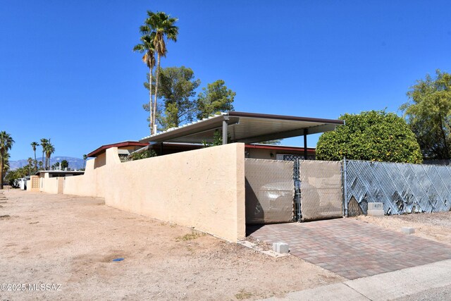 view of home's exterior with stucco siding and fence