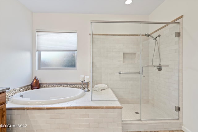 bathroom with a stall shower and a garden tub