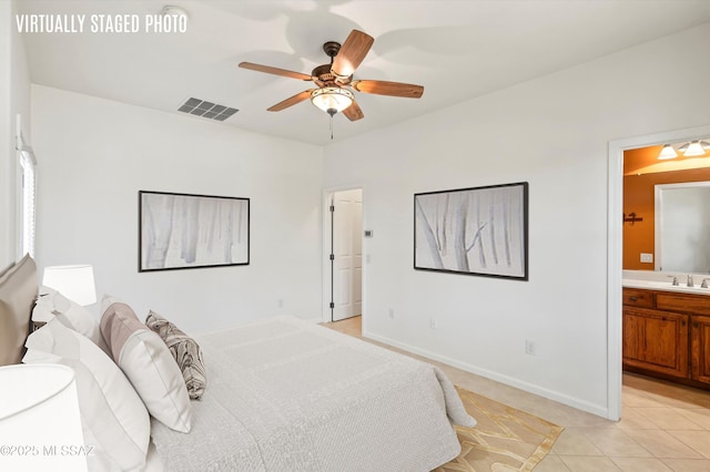bedroom featuring baseboards, light tile patterned floors, ensuite bathroom, visible vents, and a sink