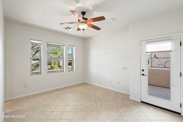 empty room featuring baseboards, a ceiling fan, and visible vents