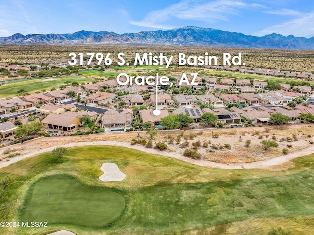 drone / aerial view featuring golf course view, a mountain view, and a residential view