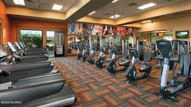 workout area featuring visible vents, a drop ceiling, and carpet