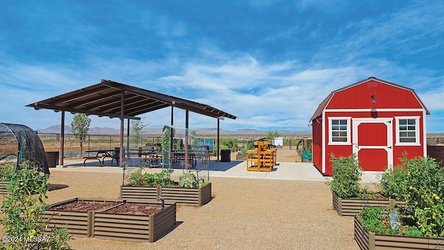 exterior space featuring an outbuilding, a mountain view, a vegetable garden, and a shed