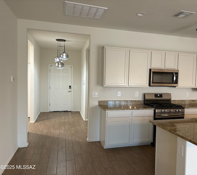7481 W Elvado Rd, Tucson, AZ 85757 - kitchen featuring visible vents, white cabinets, dark wood-style floors, and stainless steel appliances