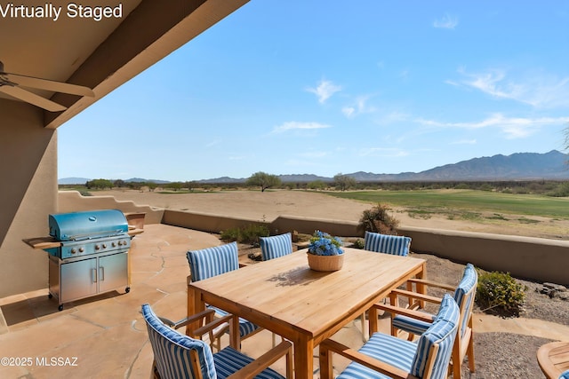 view of patio / terrace with outdoor dining space, a mountain view, and area for grilling