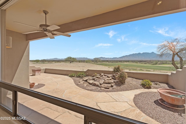 view of patio featuring a mountain view and a ceiling fan