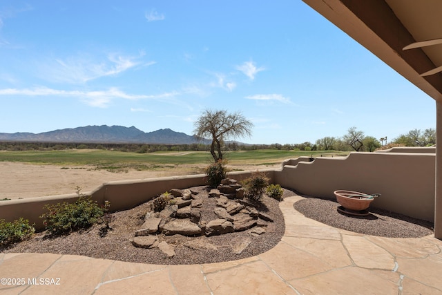 view of patio / terrace featuring a mountain view and fence