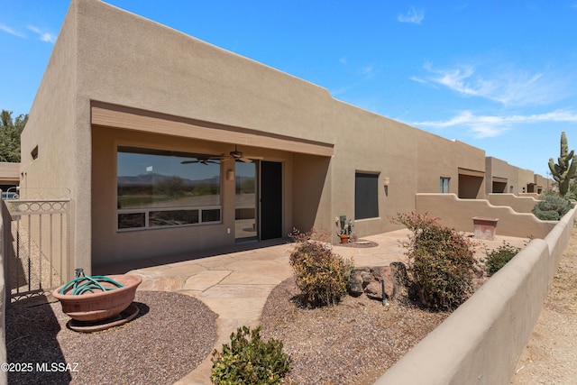 exterior space featuring fence, a patio, stucco siding, and a ceiling fan