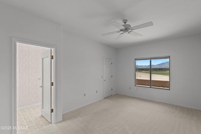 unfurnished room featuring light carpet, baseboards, and ceiling fan