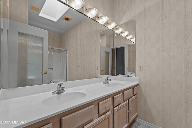 full bathroom with wallpapered walls and a sink