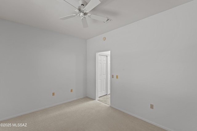 spare room featuring baseboards, light colored carpet, and a ceiling fan