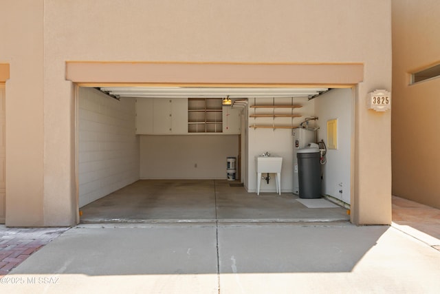 garage featuring electric water heater and a sink