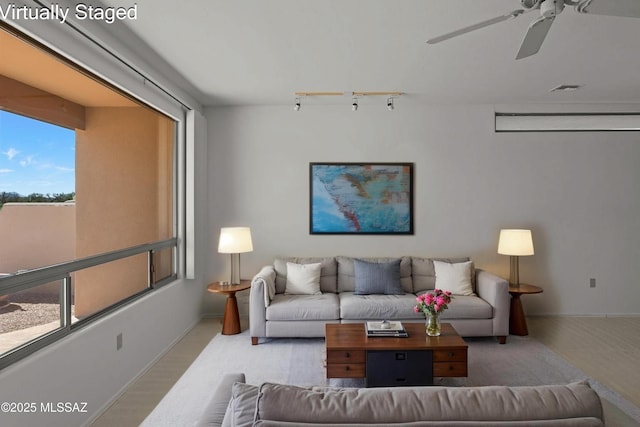 living room featuring visible vents, baseboards, a ceiling fan, and track lighting