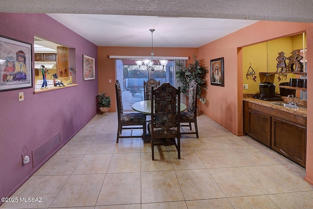 dining space featuring light tile patterned flooring, an inviting chandelier, and visible vents