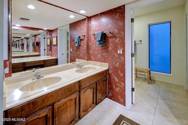 full bathroom with wallpapered walls, a sink, and baseboards