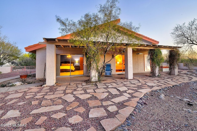 back of property featuring a patio, stucco siding, fence, and a tile roof