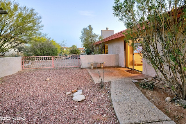 view of yard featuring a patio area, fence, and a gate