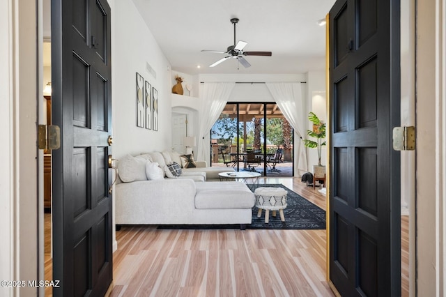 living area with light wood finished floors, visible vents, and a ceiling fan